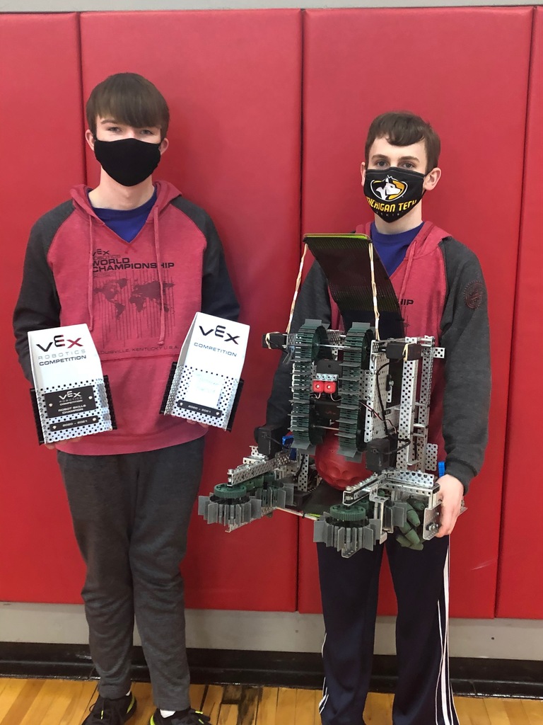 two boys holding a robot and trophy